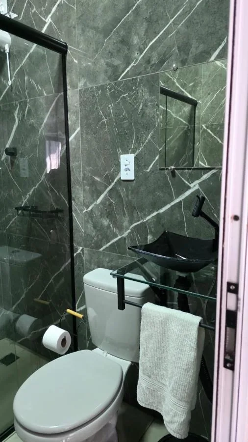 Banheiro com box de vidro e chuveiro quente