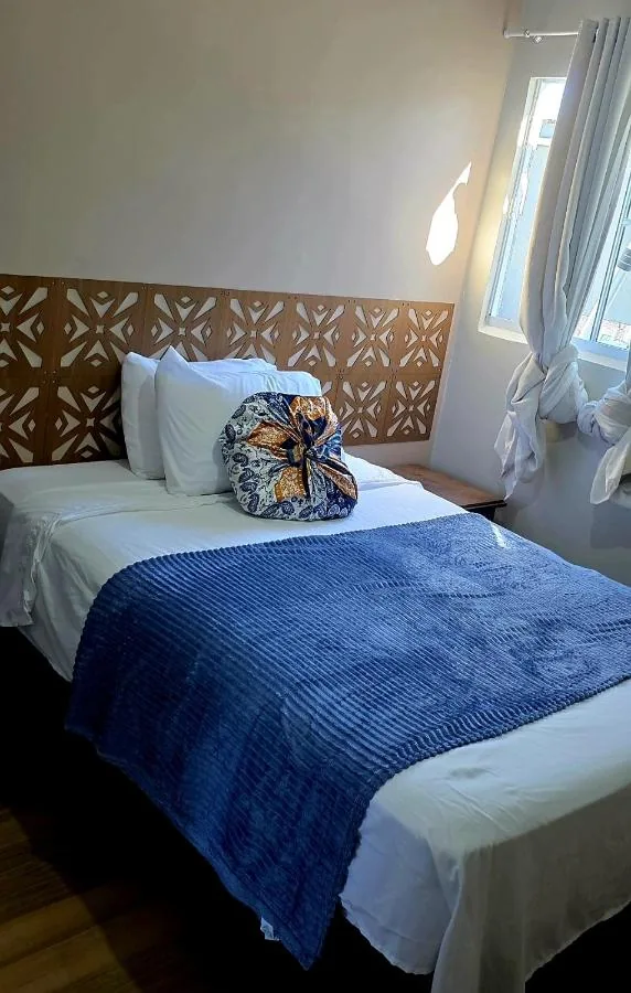 Suíte com cama de casal e manta azul acolhedora