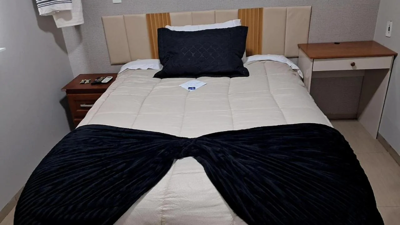 Cama com edredom preto e branco higienizado e cheiroso